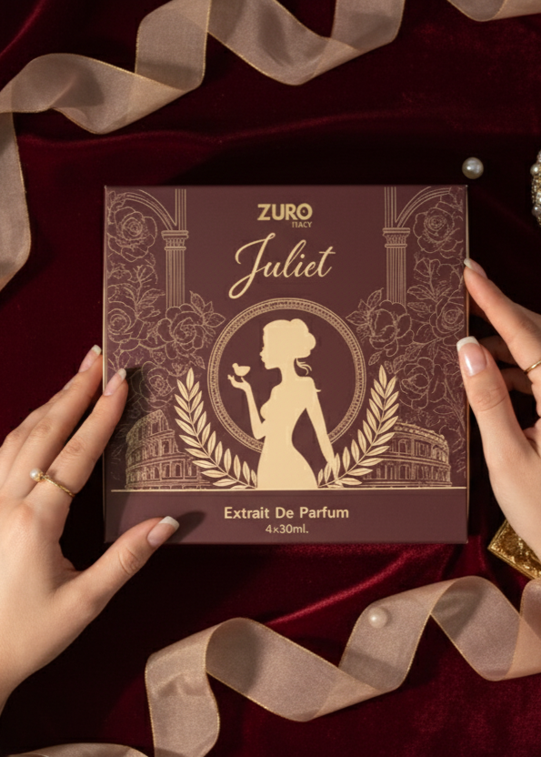 Zuro Juliet perfume extract packaging on a red fabric background with hands holding it.